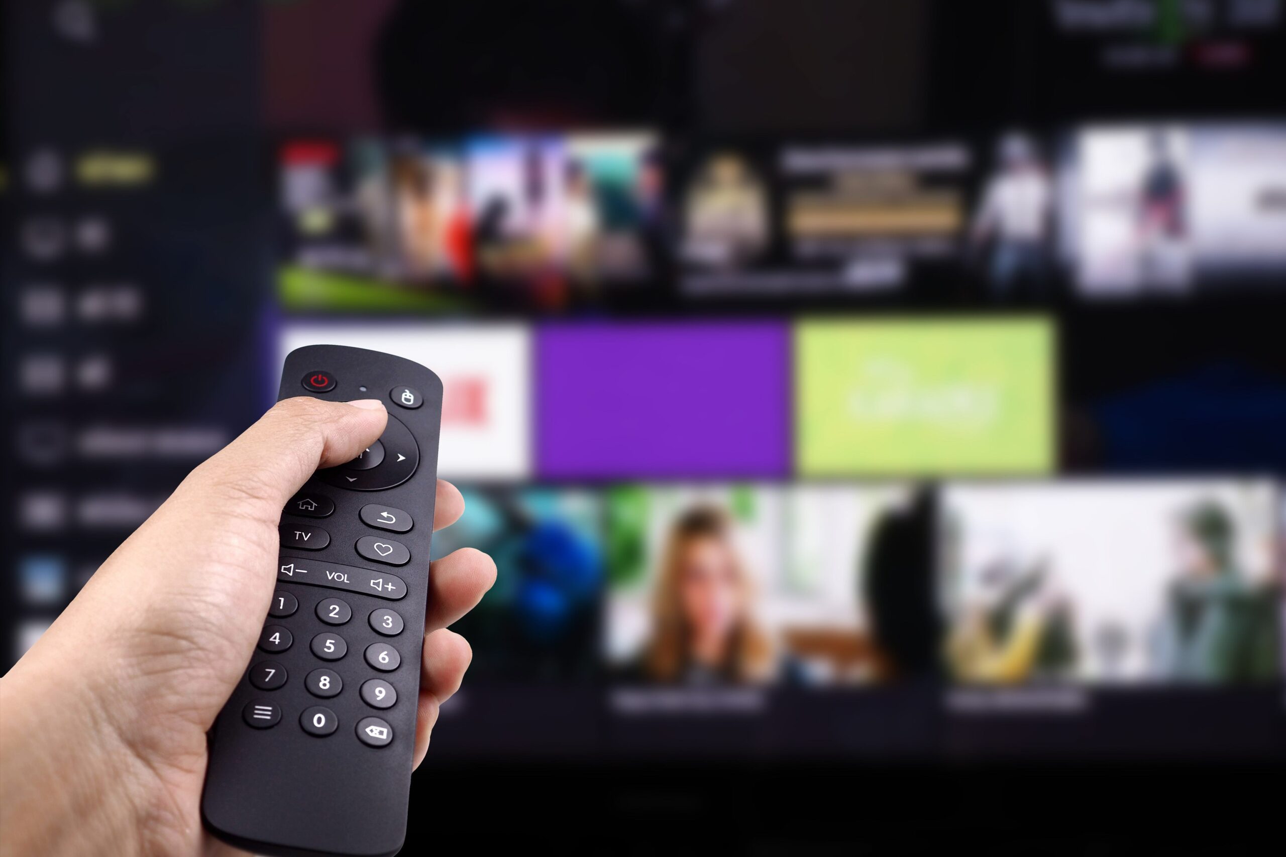 Hand holding tv remote control with Smart TV
